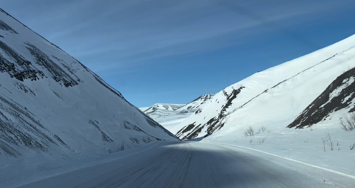 Snowy mountain landscape with a clear blue sky. Road to the Arctic Ocean, Canada.