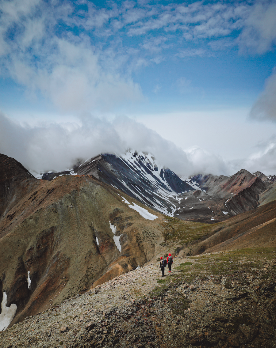 Hikers trekking along the Donjek Trail, navigating the rugged terrain of the Yukon wilderness.