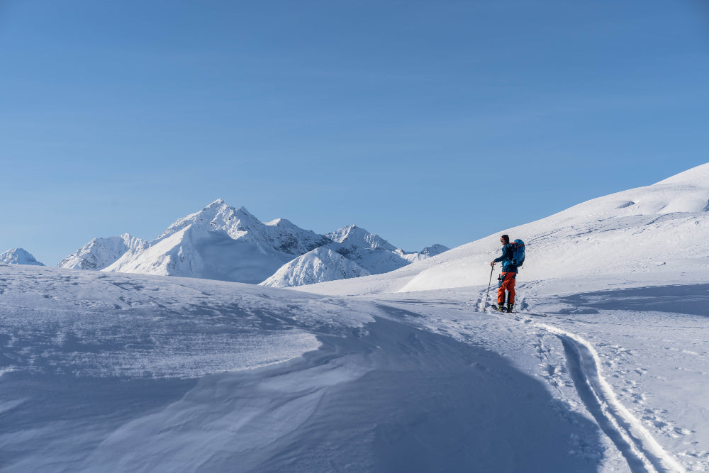 Person skiing on a snowy mountain White Pass Yukon Canada with clear blue sky
