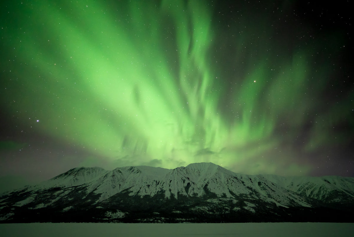 Aurora borealis over a snowy mountain landscape