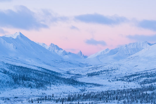 Snowy mountain landscape with a pinkish sky