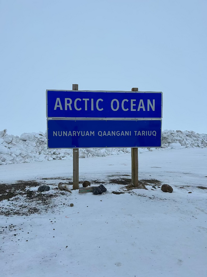 Blue sign indicating 'Arctic Ocean' in white text, with a snowy background.