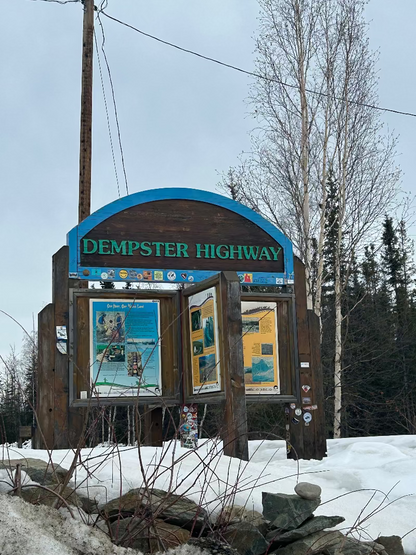 Sign for Dempster Highway with winter landscape