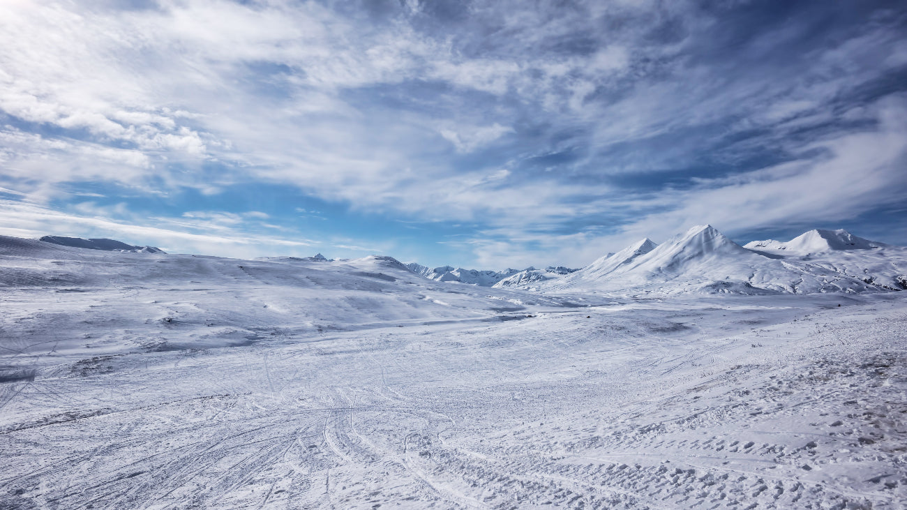 Snowy landscape with mountains under a blue sky