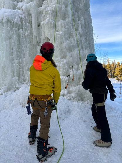 The guide demonstrates ice climbing techniques to the clients, offering expert tips and guidance before they begin their climb. With the towering ice wall of Mount Sima as their backdrop, the group prepares for an exciting and safe adventure, learning the essential skills to conquer the frozen challenge.