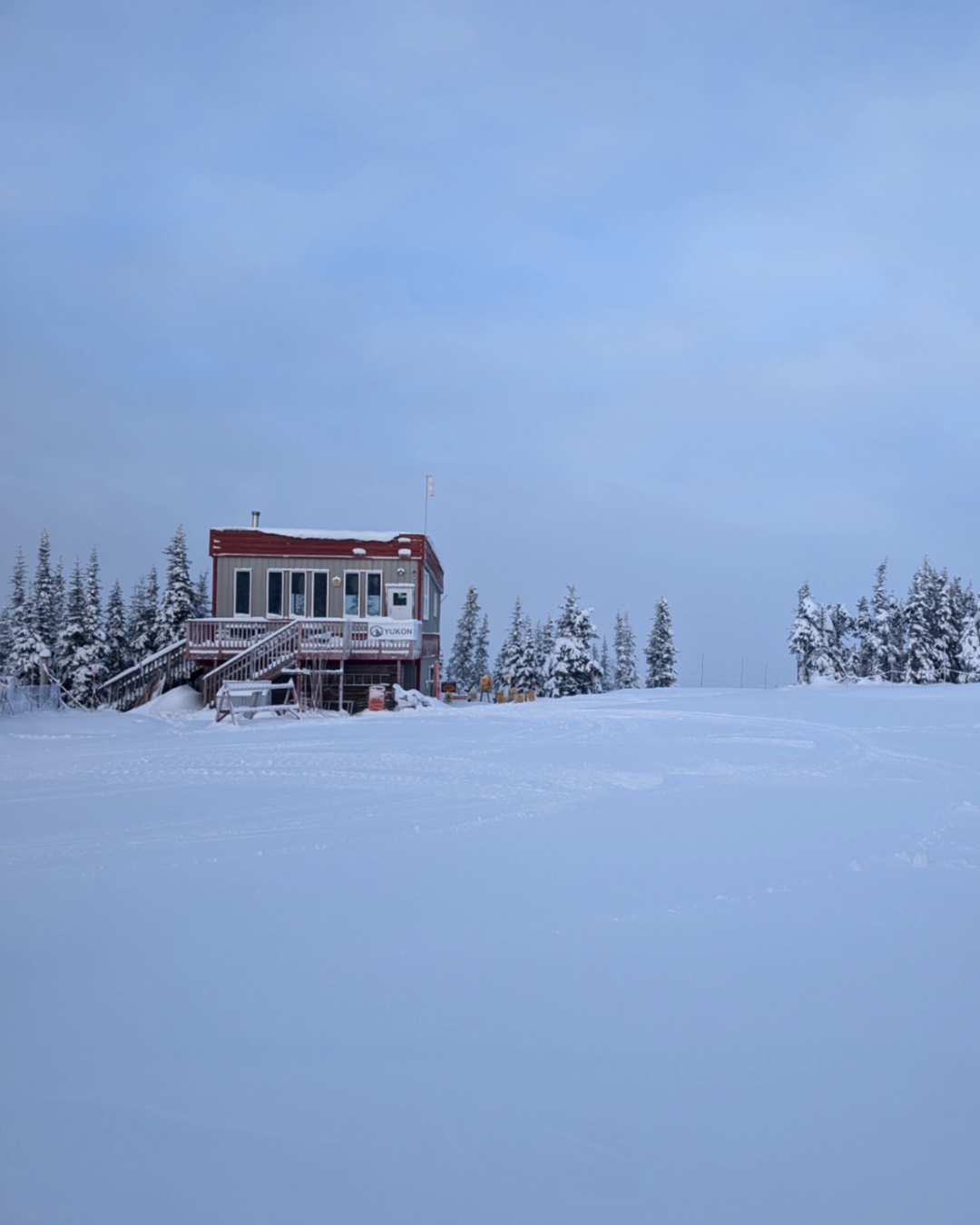 Small cabin in a snowy landscape with a clear sky