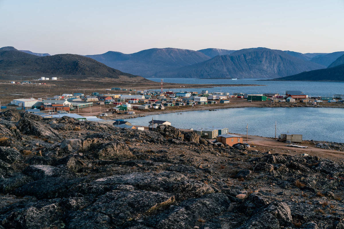 Dusk in a harsh arctic landscape with bare hills and ocean. Overlook of Inuit settlement of Qikiqtarjuaq, Broughton Island