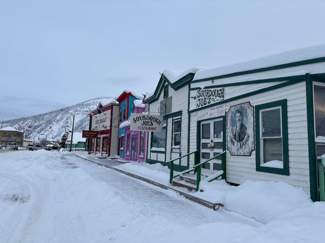 Old saloon style buildings with board walk in the winter with snow, Dawson City Yukon Canada.