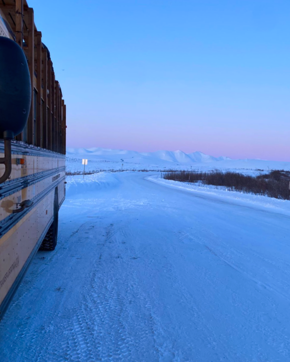 The Squatch bus on a snowy Dempster Highway Yukon Canada, dusk