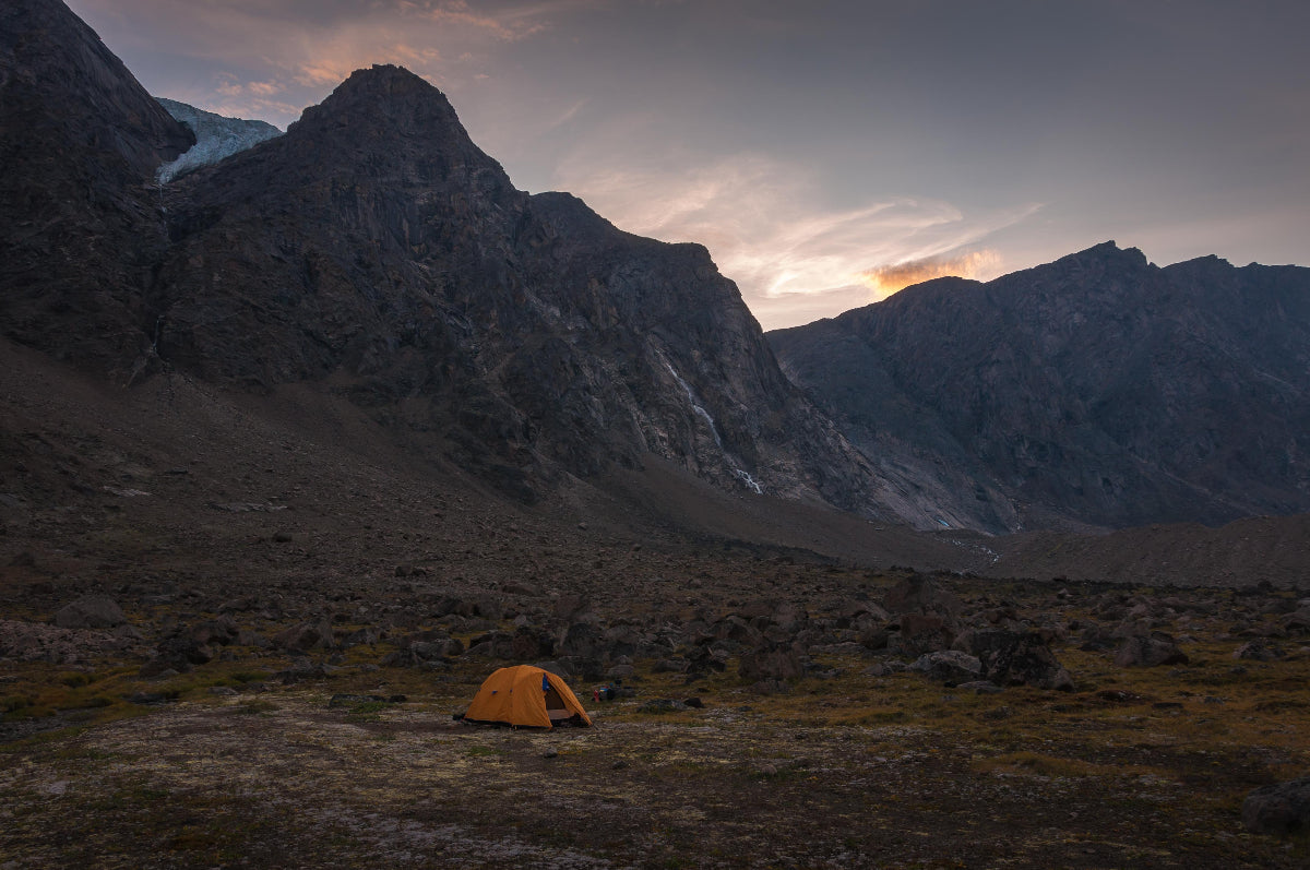 Orange tent in a mountainous landscape with a sunset, Summit Valley Akshayuk Pass, Auyuittuq National Park