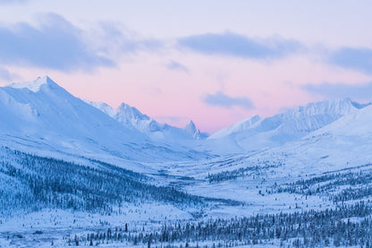 Snowy mountain landscape with a pinkish sky