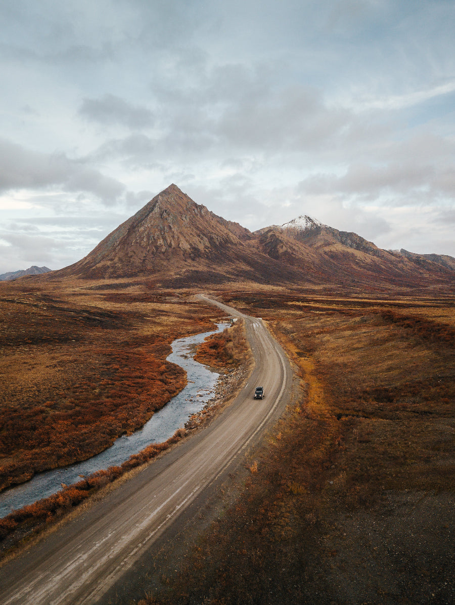Winding Dempster Highway cutting through fall tundra