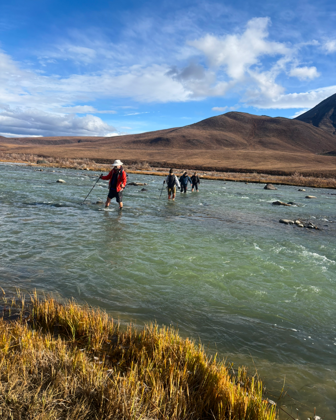Hikers crossing Blackstone River in Tombstone Yukon
